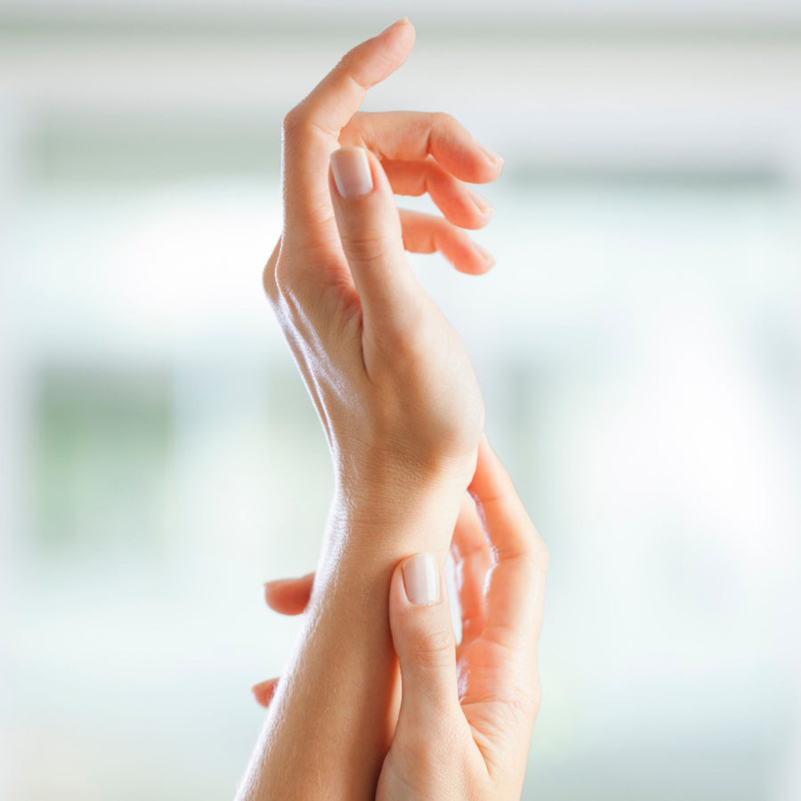 Hands gently tapping at the wrist in soft light