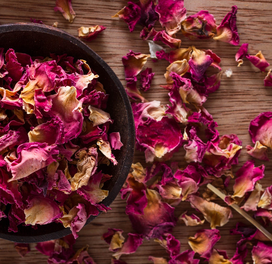 Dried rose petals in a wooden bowl